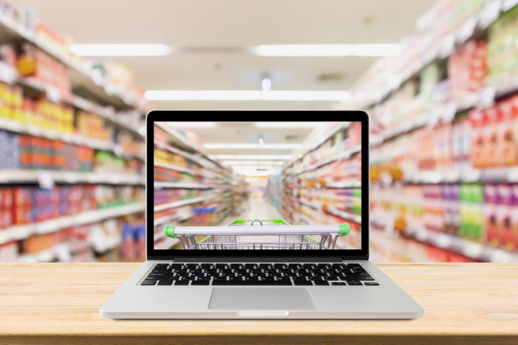 laptop on a table showing grocery online store