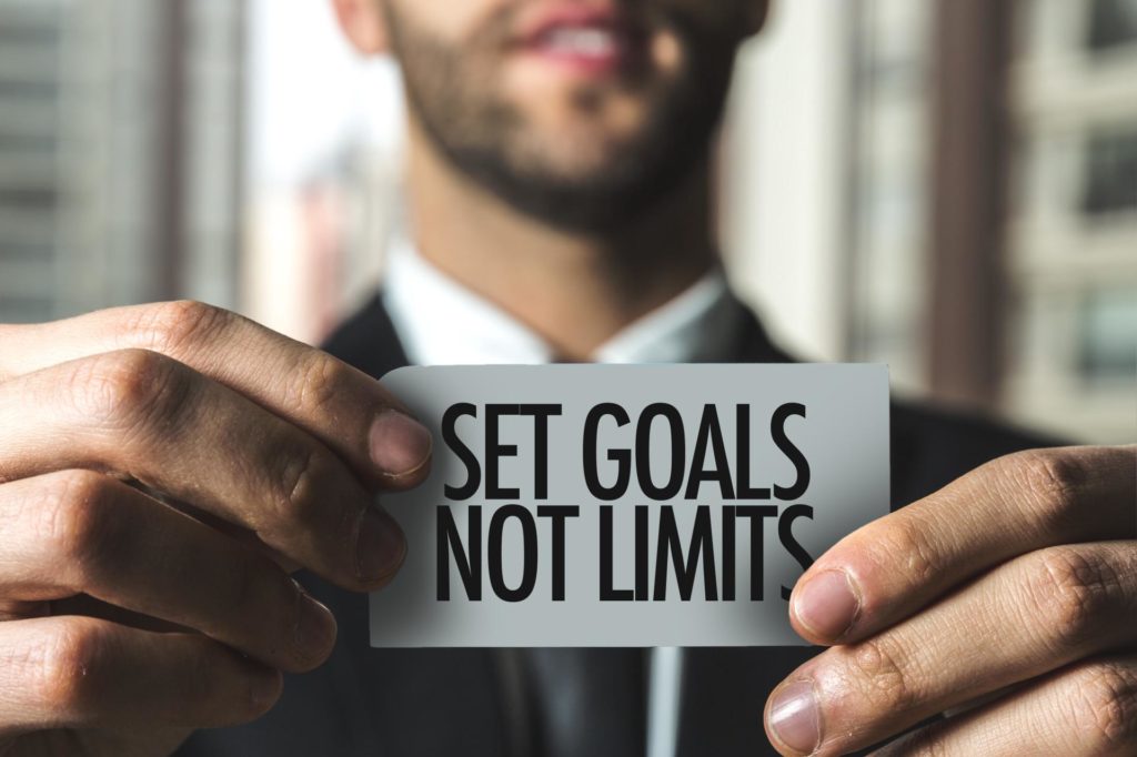 man holding card setting goals not limits