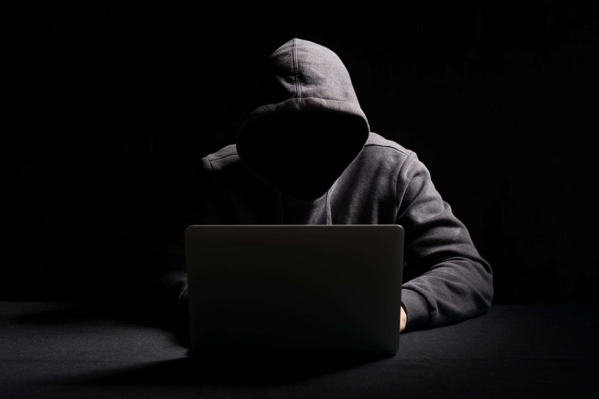 hacker in a black hoodie with laptop hacking an online store showing what entrepreneurs can learn from hackers